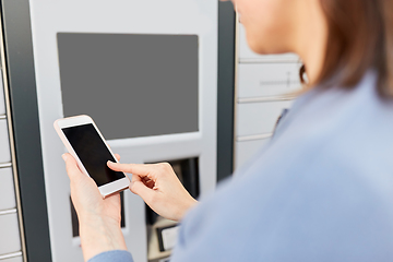 Image showing woman with smartphone at automated parcel machine