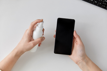 Image showing close up of woman cleaning smartphone