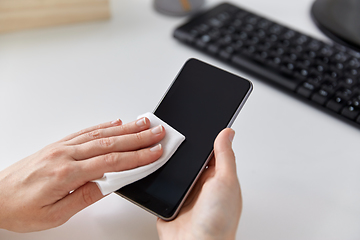 Image showing close up of hands cleaning smartphone with tissue