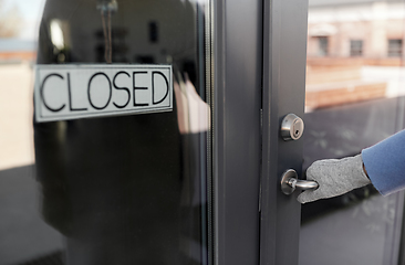 Image showing hand in glove trying to open closed office door