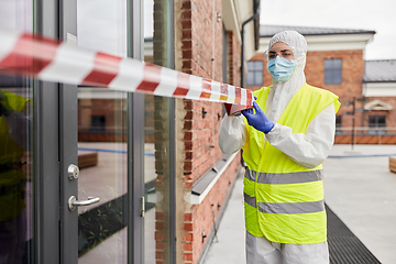 Image showing healthcare worker sealing door with caution tape