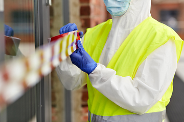 Image showing healthcare worker sealing door with caution tape