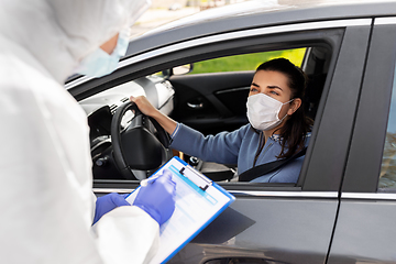 Image showing healthcare worker with clipboard and woman in car