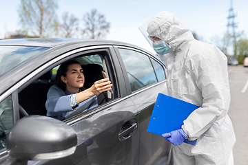 Image showing woman in car showing phohe to healthcare worker