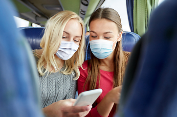 Image showing women in masks in travel bus with smartphone