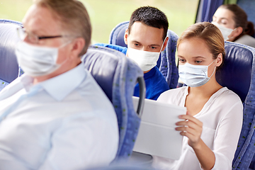 Image showing couple in masks with tablet pc in travel bus