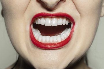 Image showing Close-up female mouth with bright red gloss lips make-up. Cosmetology, dentistry and beauty care, emotions