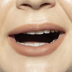 Image showing Close-up female mouth with natural nude gloss lips make-up. Cosmetology, dentistry and beauty care, emotions