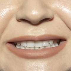 Image showing Close-up female mouth with natural nude gloss lips make-up. Cosmetology, dentistry and beauty care, emotions