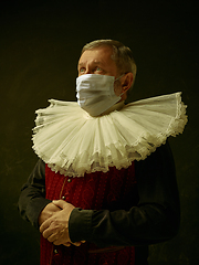 Image showing Senior man as a medieval knight on dark background wearing protective mask against coronavirus