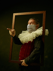 Image showing Senior man as a medieval knight on dark background wearing protective mask against coronavirus