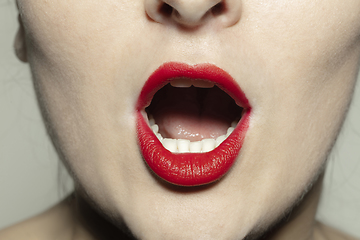 Image showing Close-up female mouth with bright red gloss lips make-up. Cosmetology, dentistry and beauty care, emotions