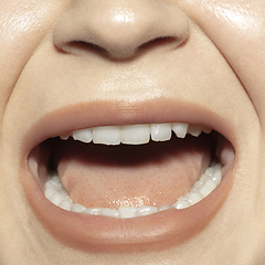 Image showing Close-up female mouth with natural nude gloss lips make-up. Cosmetology, dentistry and beauty care, emotions