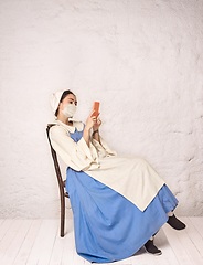 Image showing Medieval young woman as a lady milkmade wearing protective mask against coronavirus spread