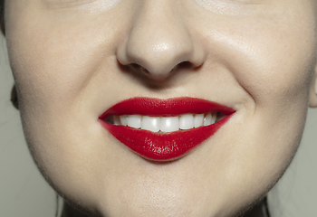 Image showing Close-up female mouth with bright red gloss lips make-up. Cosmetology, dentistry and beauty care, emotions