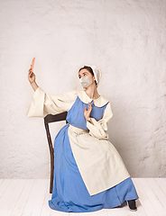 Image showing Medieval young woman as a lady milkmade wearing protective mask against coronavirus spread