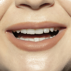 Image showing Close-up female mouth with natural nude gloss lips make-up. Cosmetology, dentistry and beauty care, emotions