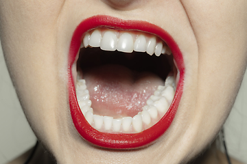 Image showing Close-up female mouth with bright red gloss lips make-up. Cosmetology, dentistry and beauty care, emotions