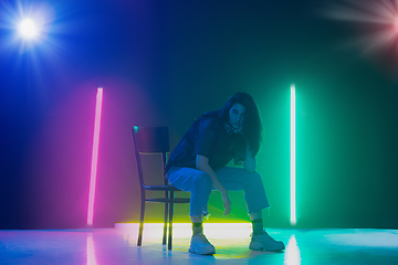 Image showing Young caucasian girl posing stylish in neon light on dark background