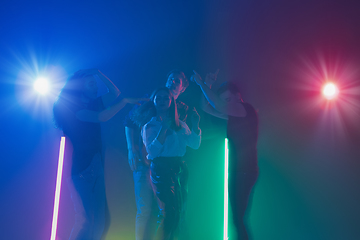 Image showing Cheering dance party, performance concept. Crowd shadow of people dancing with neon lights raised hands up