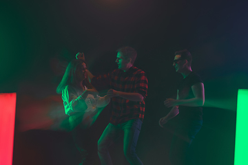 Image showing Cheering dance party, performance concept. Crowd shadow of people dancing with neon lights raised hands up