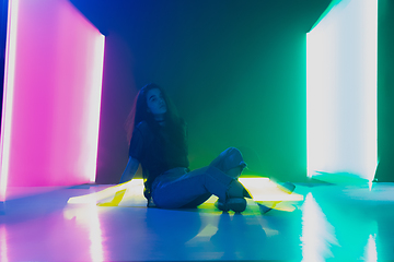 Image showing Young caucasian girl posing stylish in neon light on dark background