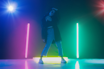 Image showing Young caucasian girl posing stylish in neon light on dark background