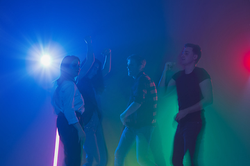 Image showing Cheering dance party, performance concept. Crowd shadow of people dancing with neon lights raised hands up