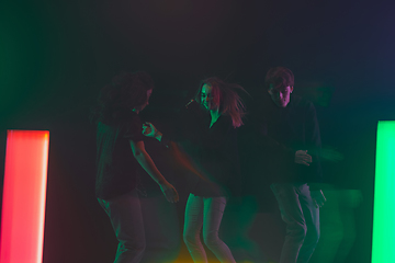 Image showing Cheering dance party, performance concept. Crowd shadow of people dancing with neon lights raised hands up