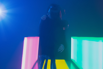Image showing Cheering dance party, performance concept. Couple hugging in neon lights, romantic and lovely