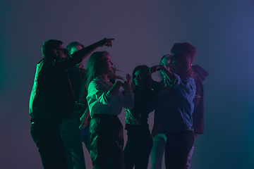 Image showing Cheering dance party, performance concept. Crowd shadow of people dancing with neon lights raised hands up