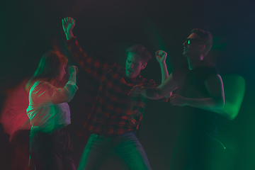 Image showing Cheering dance party, performance concept. Crowd shadow of people dancing with neon lights raised hands up