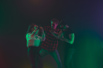 Image showing Cheering dance party, performance concept. Crowd shadow of people dancing with neon lights raised hands up