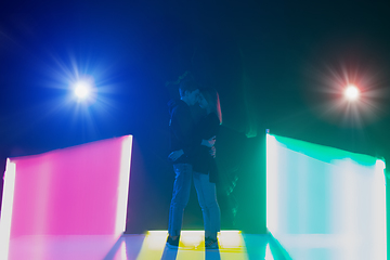 Image showing Cheering dance party, performance concept. Couple hugging in neon lights, romantic and lovely