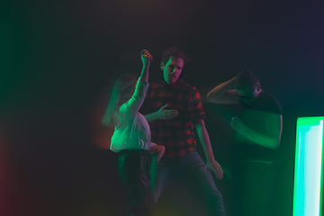 Image showing Cheering dance party, performance concept. Crowd shadow of people dancing with neon lights raised hands up