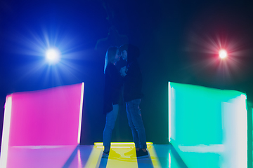 Image showing Cheering dance party, performance concept. Couple hugging in neon lights, romantic and lovely