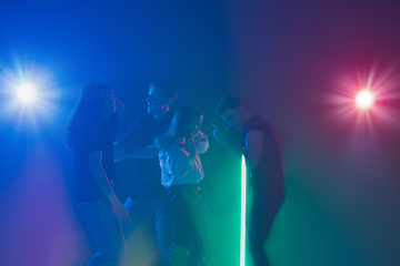 Image showing Cheering dance party, performance concept. Crowd shadow of people dancing with neon lights raised hands up