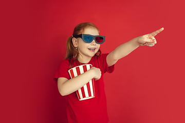 Image showing Caucasian little girl portrait isolated on red studio background, emotions concept