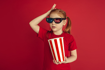 Image showing Caucasian little girl portrait isolated on red studio background, emotions concept