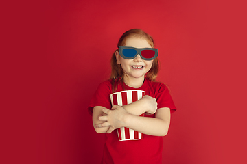 Image showing Caucasian little girl portrait isolated on red studio background, emotions concept