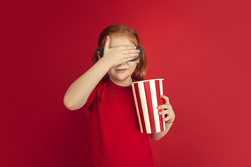 Image showing Caucasian little girl portrait isolated on red studio background, emotions concept