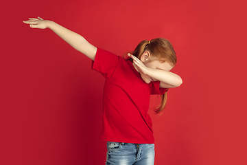 Image showing Caucasian little girl portrait isolated on red studio background, emotions concept