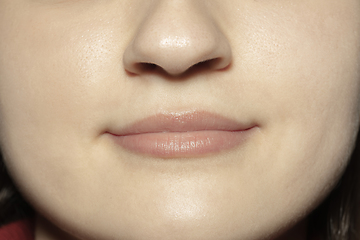 Image showing Close-up female mouth with natural nude gloss lips make-up. Cosmetology, dentistry and beauty care, emotions