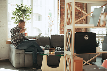 Image showing African-american man, freelancer during the work in home office while quarantine