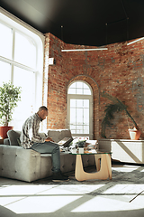 Image showing African-american man, freelancer during the work in home office while quarantine