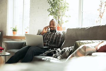 Image showing African-american man, freelancer during the work in home office while quarantine