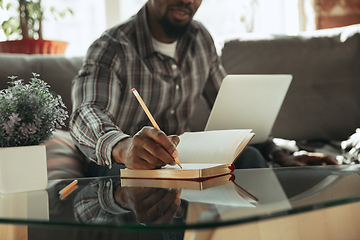 Image showing African-american man, freelancer during the work in home office while quarantine