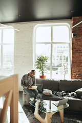 Image showing African-american man, freelancer during the work in home office while quarantine