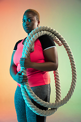 Image showing Young african-american plus size female model\'s training on gradient background