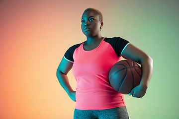 Image showing Young african-american plus size female model\'s training on gradient background